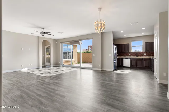 an open kitchen with a refrigerator and a stove top oven