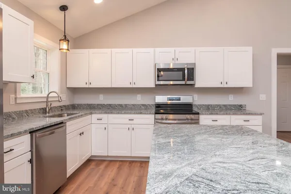 a kitchen with stainless steel appliances granite countertop a stove sink and cabinets