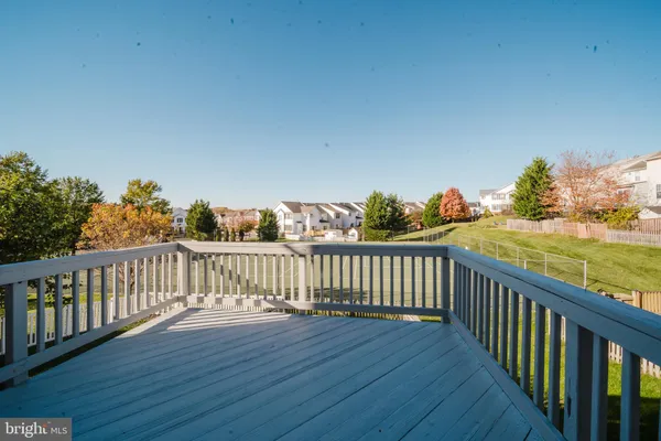 a view of a balcony with wooden floor & fence