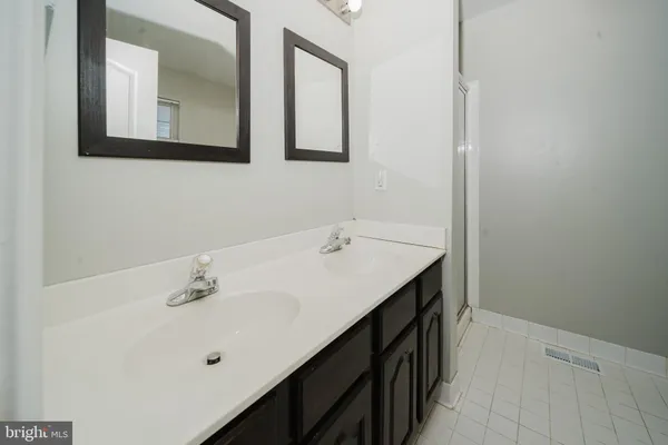 a bathroom with a double vanity sink and mirror