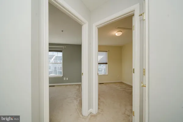 an empty room with mirror and a bathroom