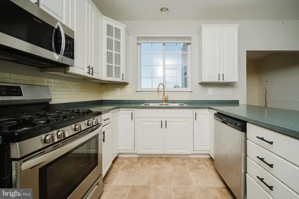 a kitchen with granite countertop cabinets stainless steel appliances and a sink
