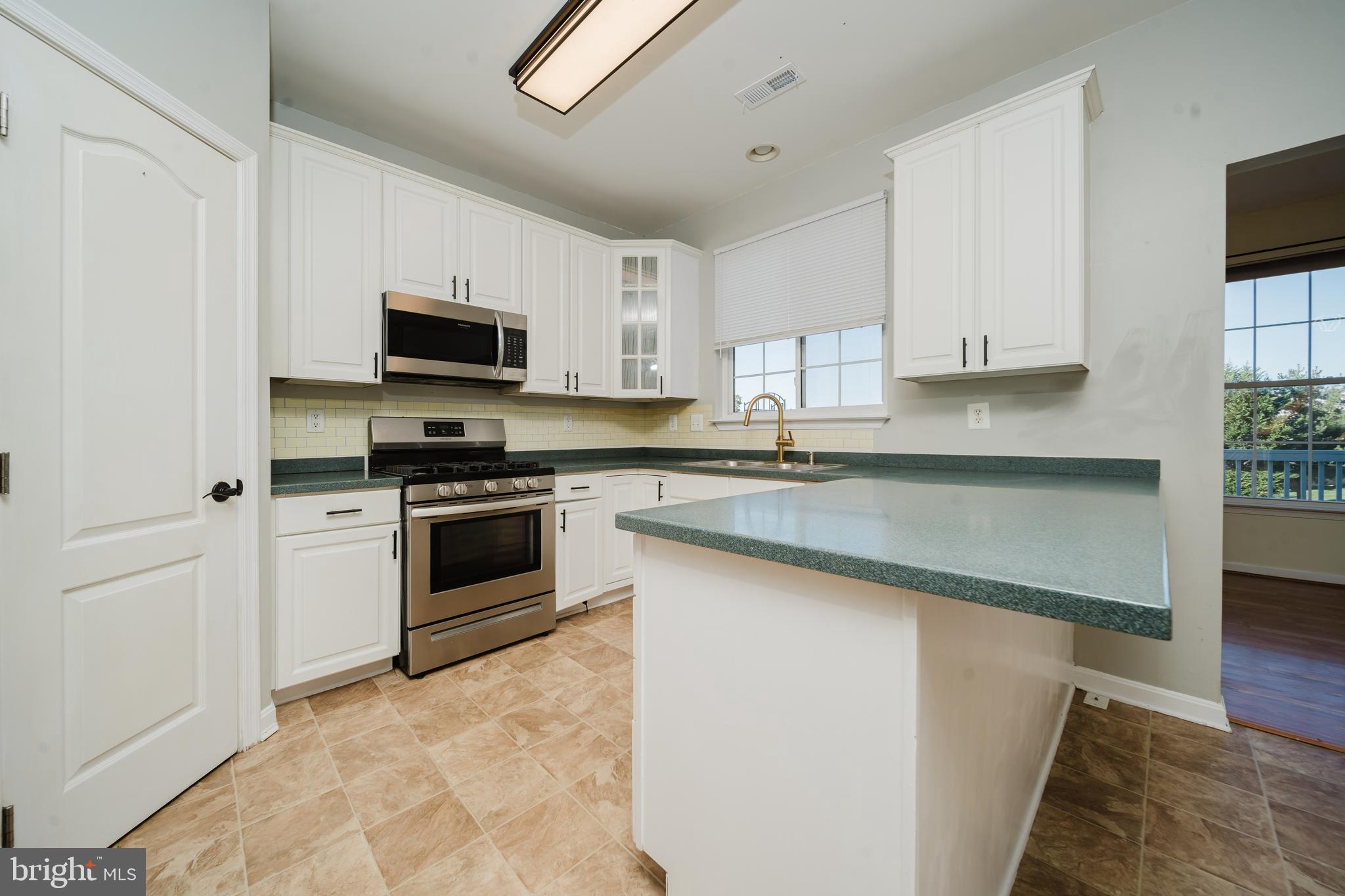 714 Kirkcaldy Way Abingdon, MD 21009 - Photo 9 of 34 a kitchen with granite countertop white cabinets and stainless steel appliances