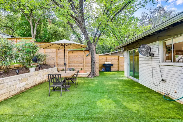 a view of a house with backyard and sitting area
