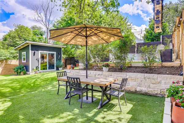 a view of patio with a table and chairs under an umbrella