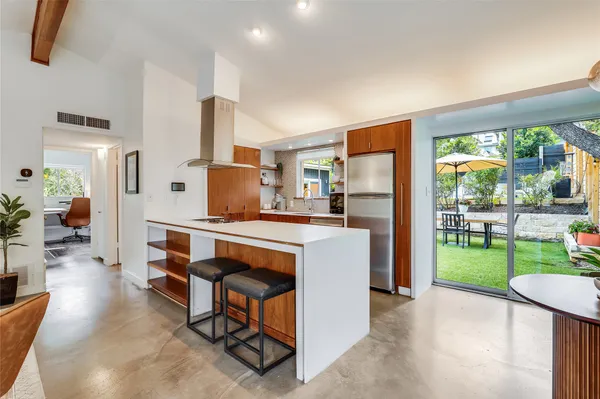 a living room with furniture a floor to ceiling window and a table