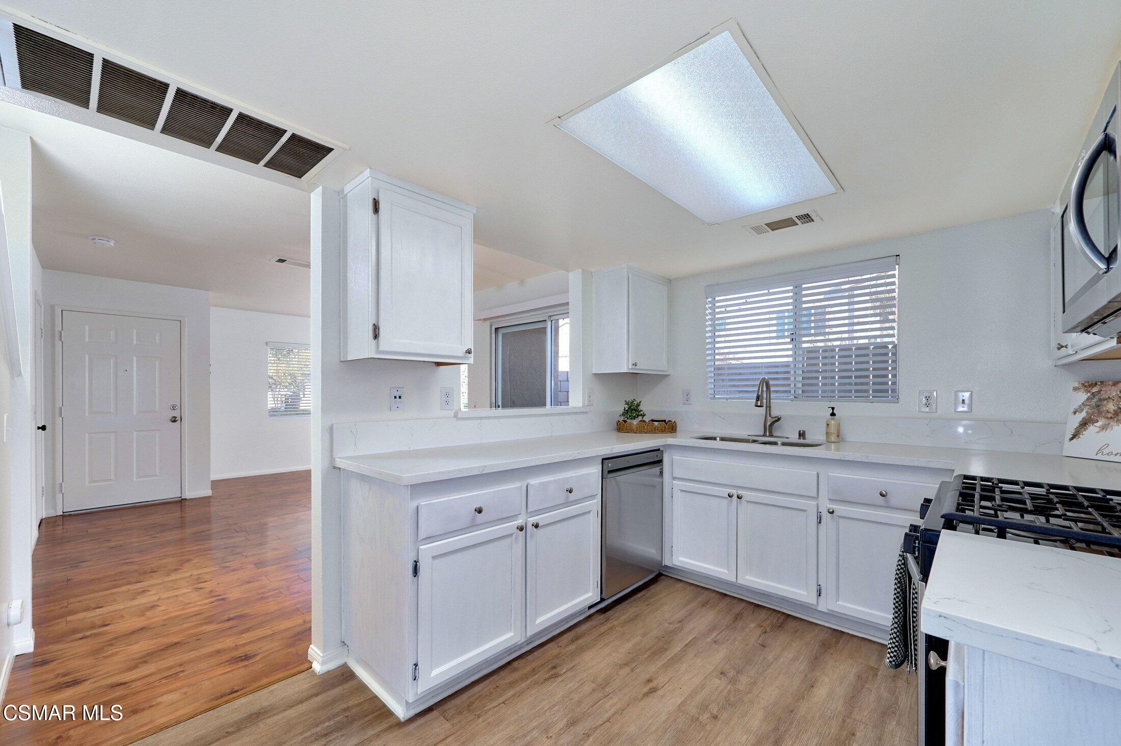 4508 Apricot Road, Unit B Simi Valley, CA 93063 - Photo 12 of 44 a kitchen with white cabinets and sink