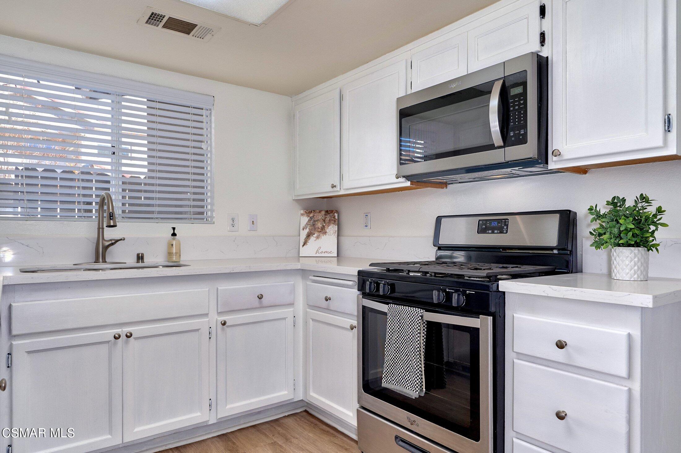 4508 Apricot Road, Unit B Simi Valley, CA 93063 - Photo 14 of 44 a kitchen with stainless steel appliances granite countertop white cabinets a stove a sink and dishwasher