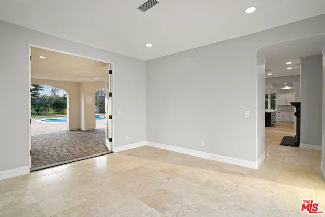 a view of a hallway with wooden floor and a bathroom