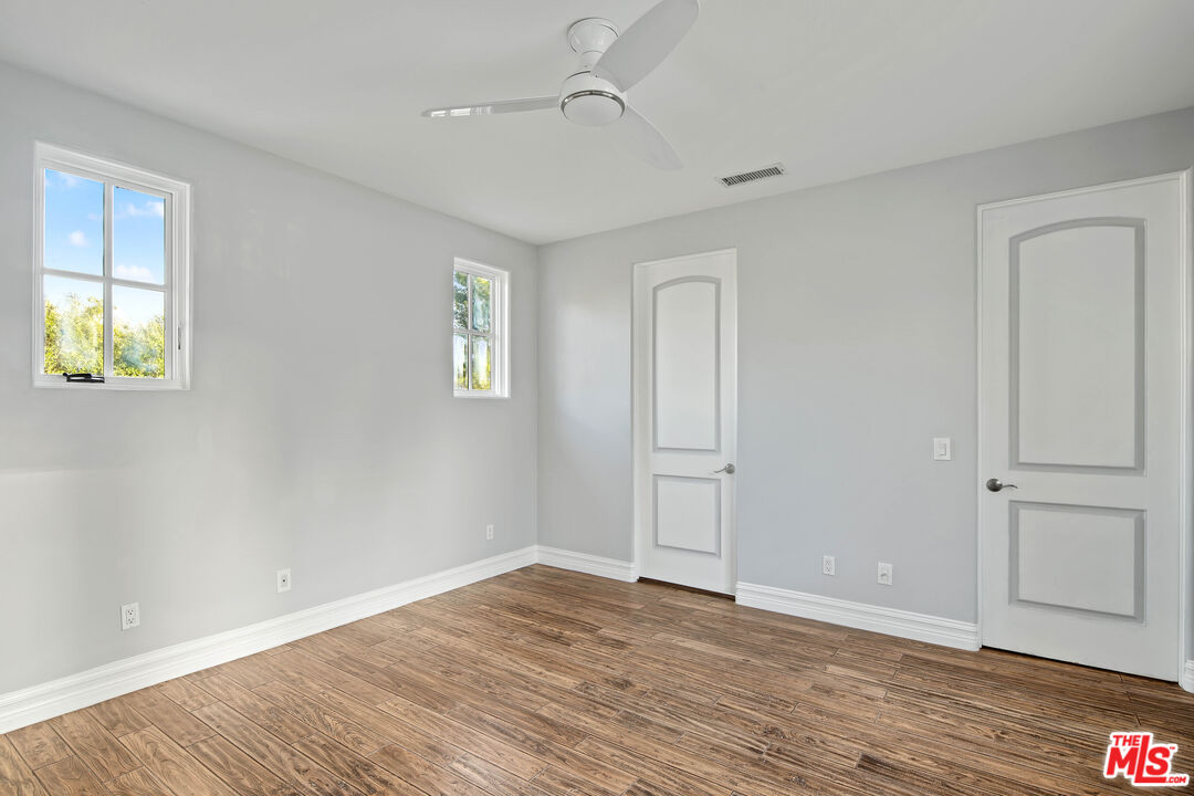 5309 Louise Avenue Encino, CA 91316 - Photo 19 of 38 an empty room with wooden floor and windows