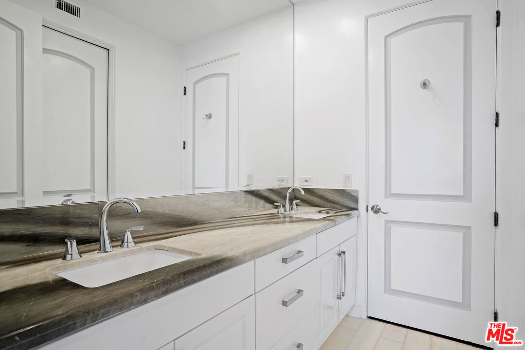 5309 Louise Avenue Encino, CA 91316 - Photo 23 of 38 a bathroom with a granite countertop sink and a mirror