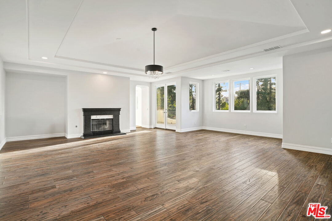 5309 Louise Avenue Encino, CA 91316 - Photo 26 of 38 a view of an empty room with wooden floor fireplace and a window
