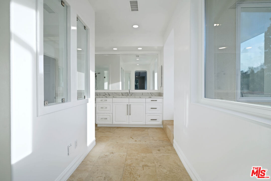 5309 Louise Avenue Encino, CA 91316 - Photo 27 of 38 a bathroom with a granite countertop sink mirror and a bathtub