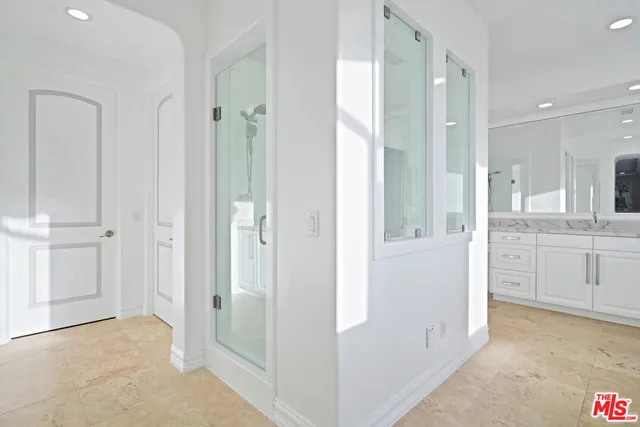 a spacious bathroom with a double vanity sink a mirror and a shower