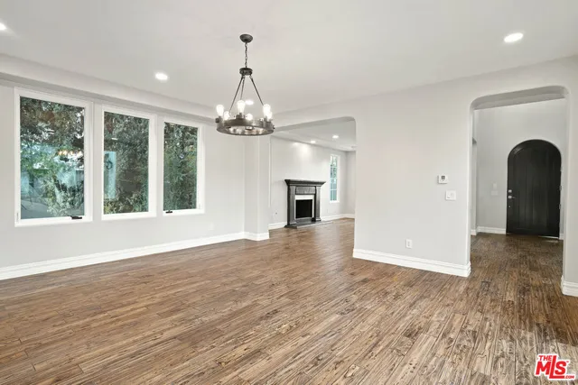 a view of a livingroom with wooden floor fireplace and a window