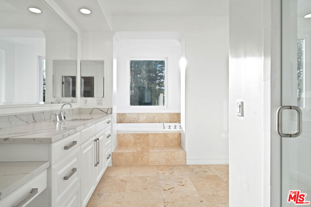 5309 Louise Avenue Encino, CA 91316 - Photo 31 of 38 a spacious bathroom with a double vanity sink a mirror and a shower