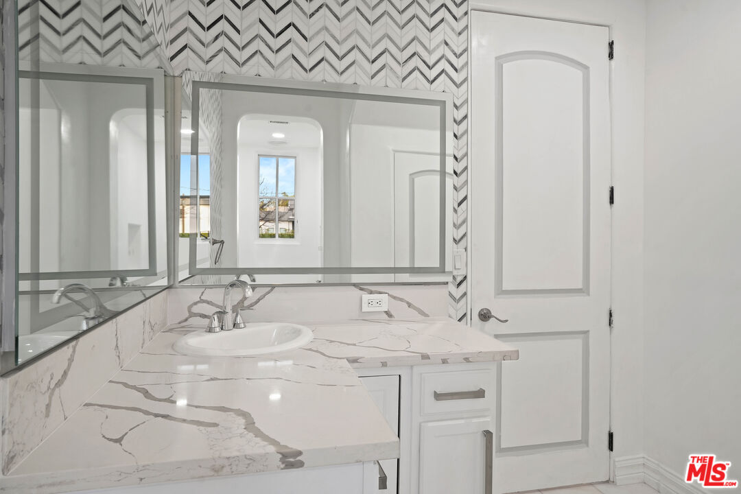 5309 Louise Avenue Encino, CA 91316 - Photo 34 of 38 a bathroom with a double vanity sink and a mirror