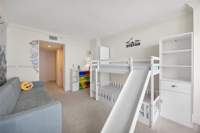 a bedroom with a bed and a flat tv screen on dresser