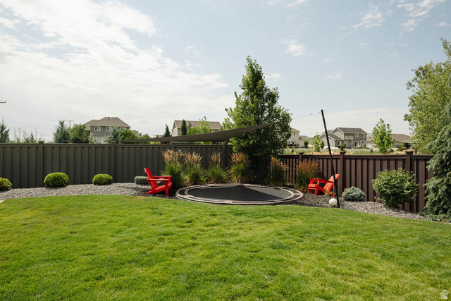 924 Country Lane Farmington, UT 84025 - Photo 75 of 91 Spacious backyard featuring a manicured lawn, a dark privacy fence, and gravel landscaping