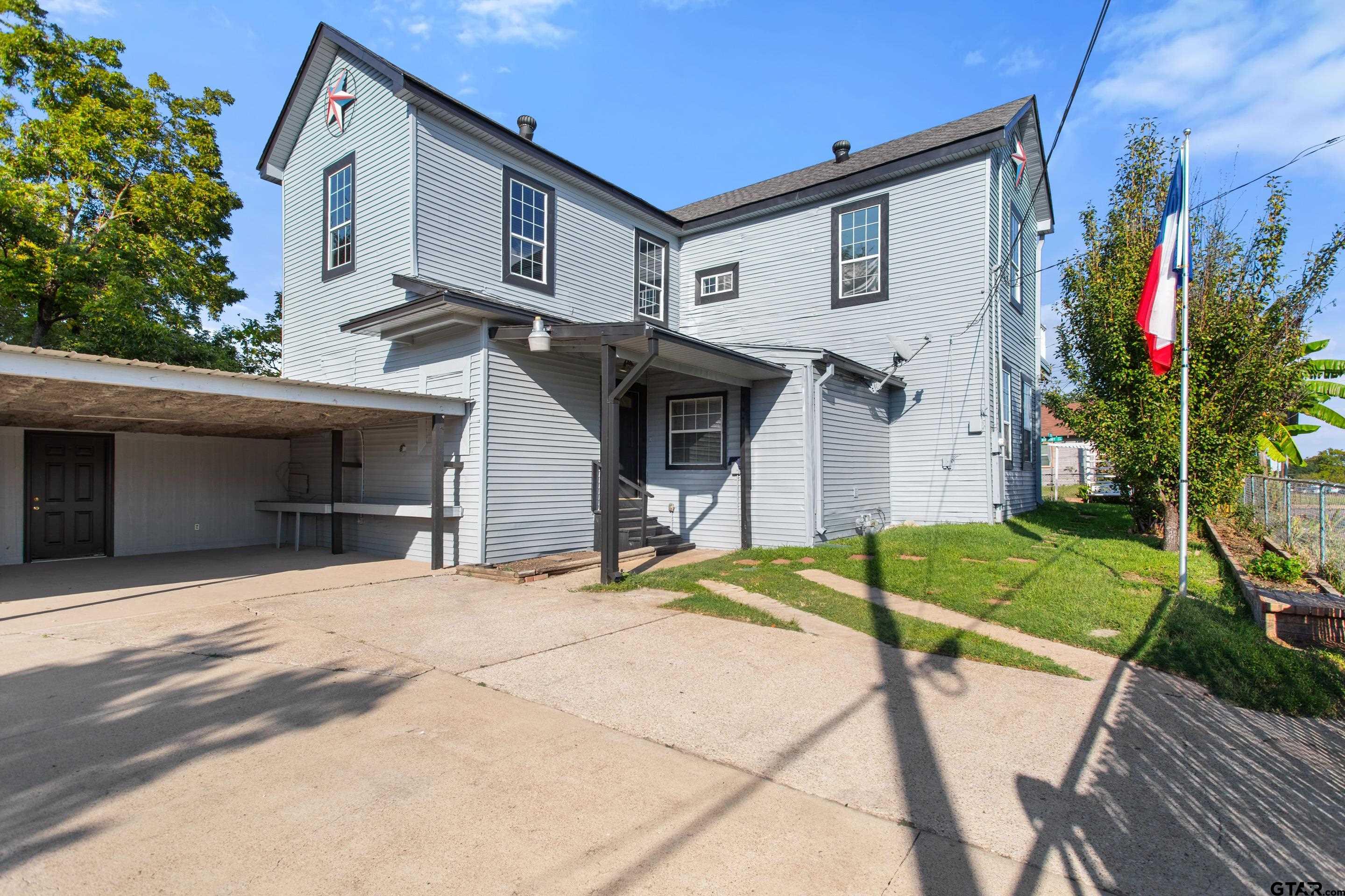 1002 North Normandy Avenue Tyler, TX 75702 - Photo 13 of 41 a front view of a house with a yard and garage