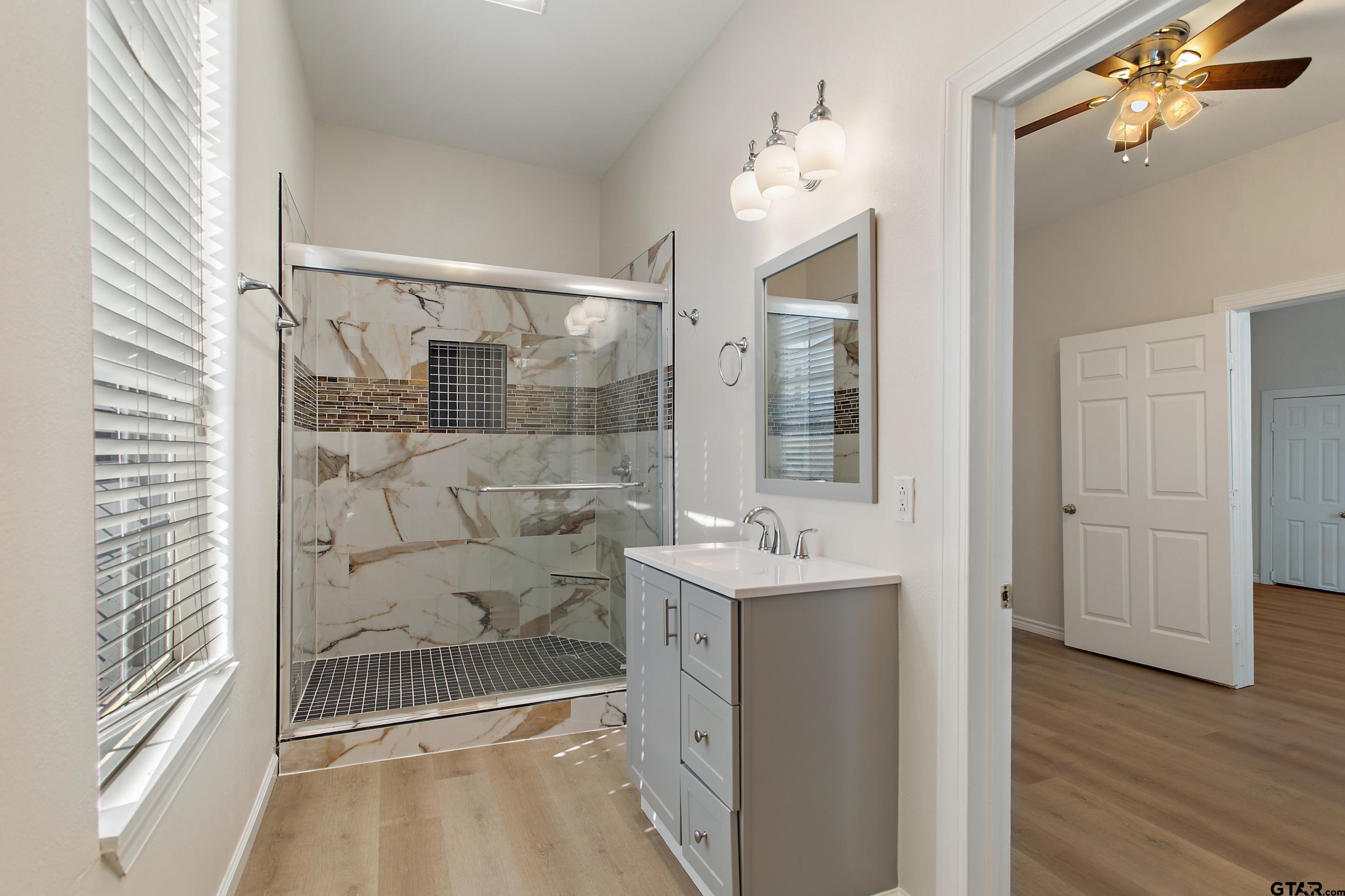 1002 North Normandy Avenue Tyler, TX 75702 - Photo 31 of 41 a bathroom with a glass shower door and a bathtub