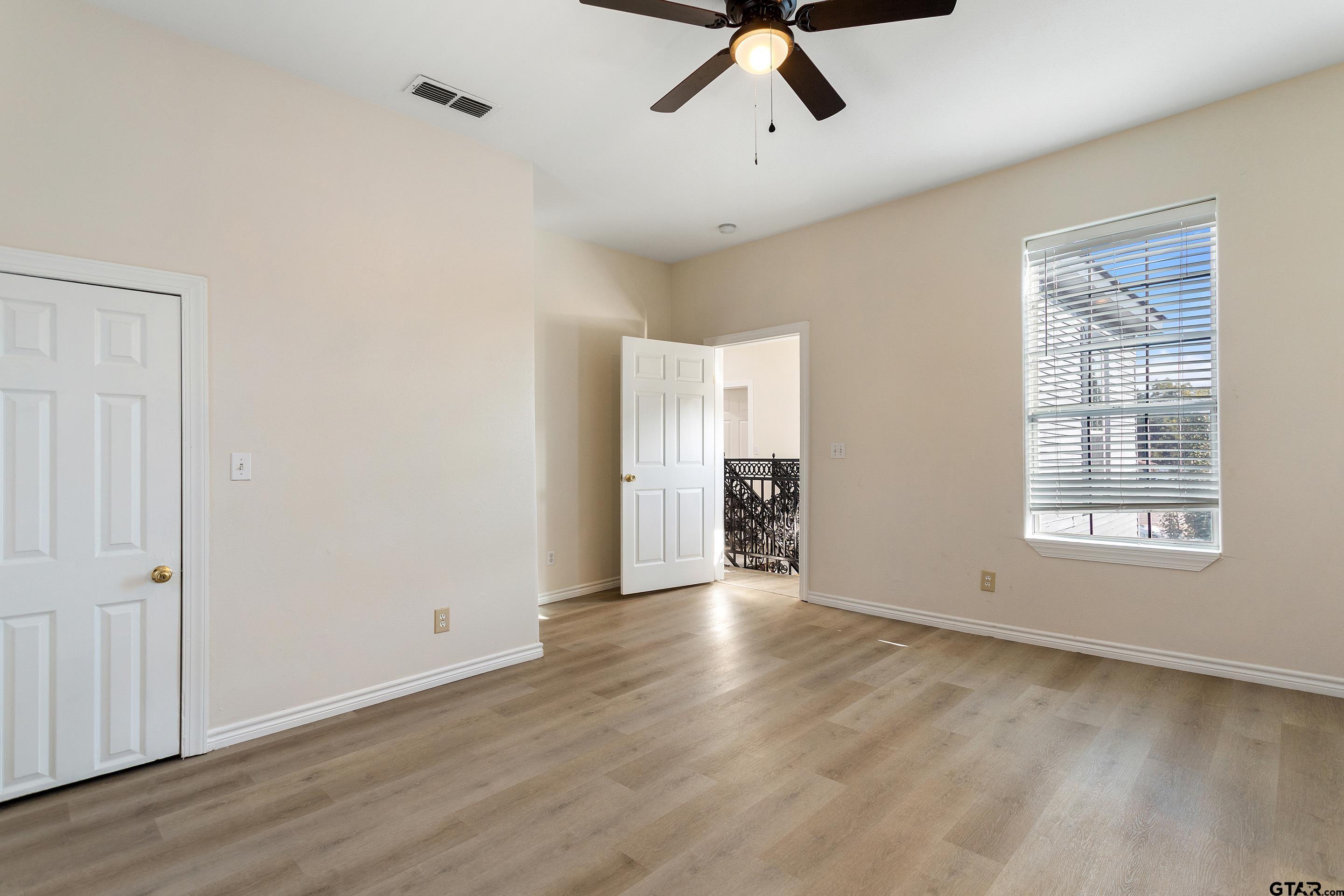1002 North Normandy Avenue Tyler, TX 75702 - Photo 34 of 41 an empty room with wooden floor cabinet and windows