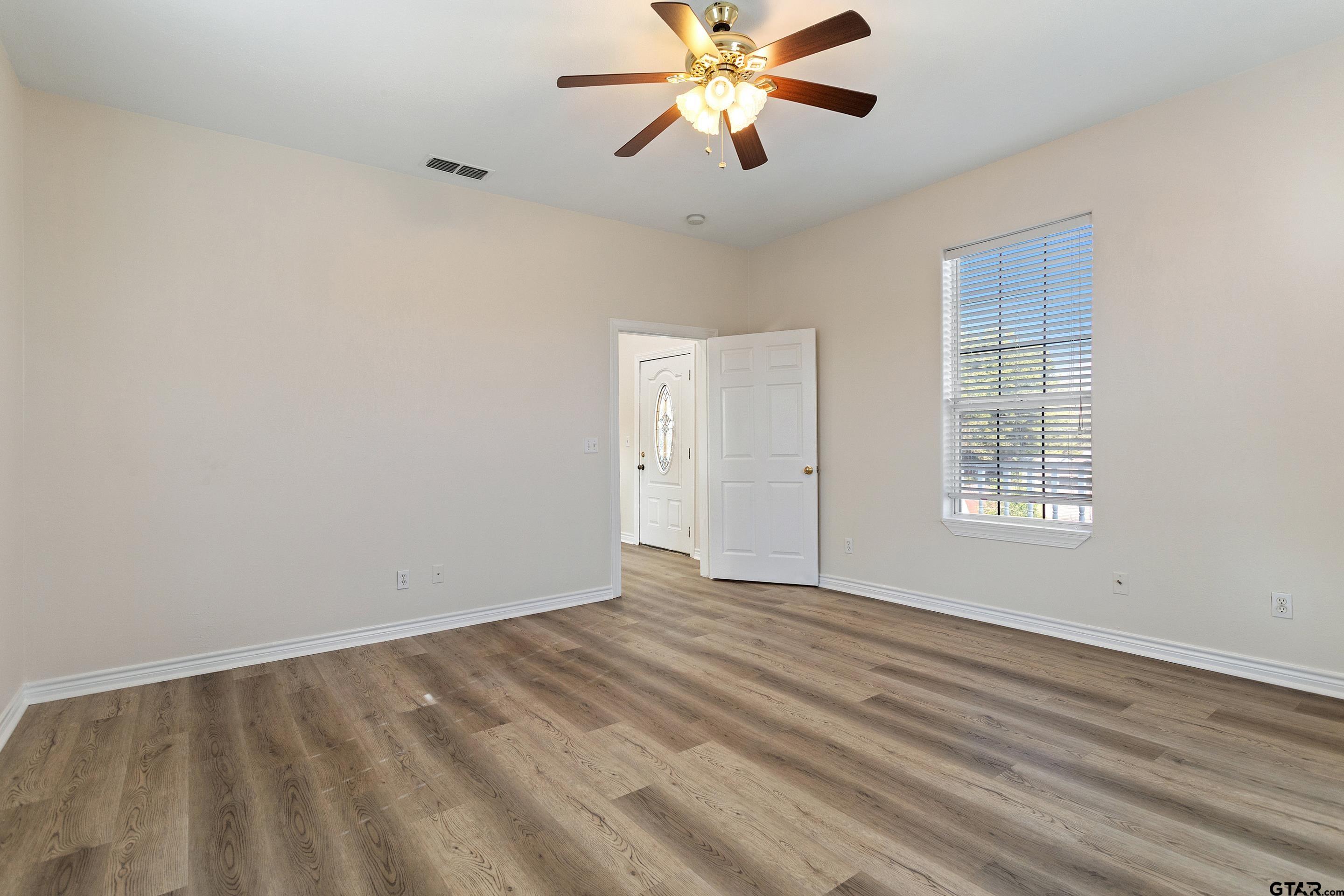 1002 North Normandy Avenue Tyler, TX 75702 - Photo 40 of 41 a view of an empty room with chandelier fan and a window
