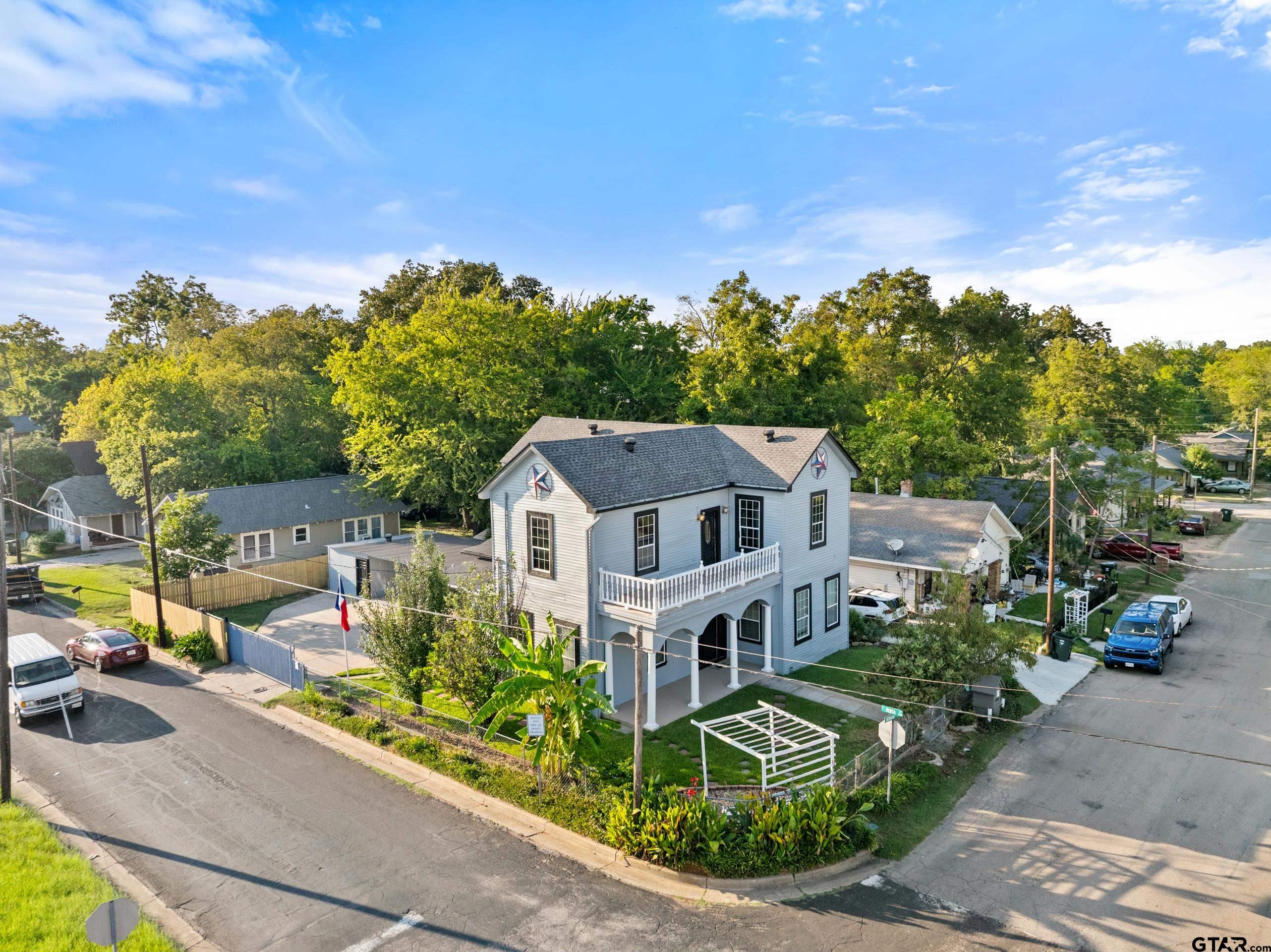 1002 North Normandy Avenue Tyler, TX 75702 - Photo 4 of 41 a front view of a house with a garden and trees