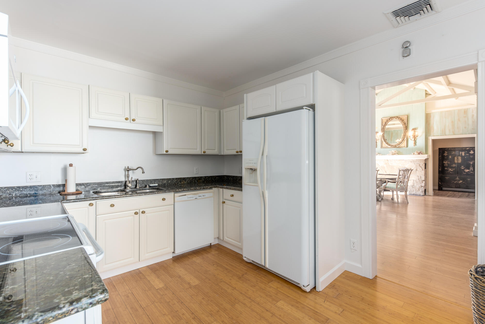 5 North Beach Road Hobe Sound, FL 33455 - Photo 12 of 26 a kitchen with granite countertop a refrigerator a sink dishwasher a stove top oven a dining table and chairs with wooden floor