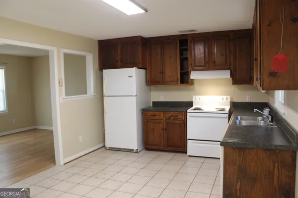 a kitchen with a refrigerator sink and cabinets