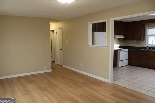 a view of a kitchen with a sink stove cabinets and empty room