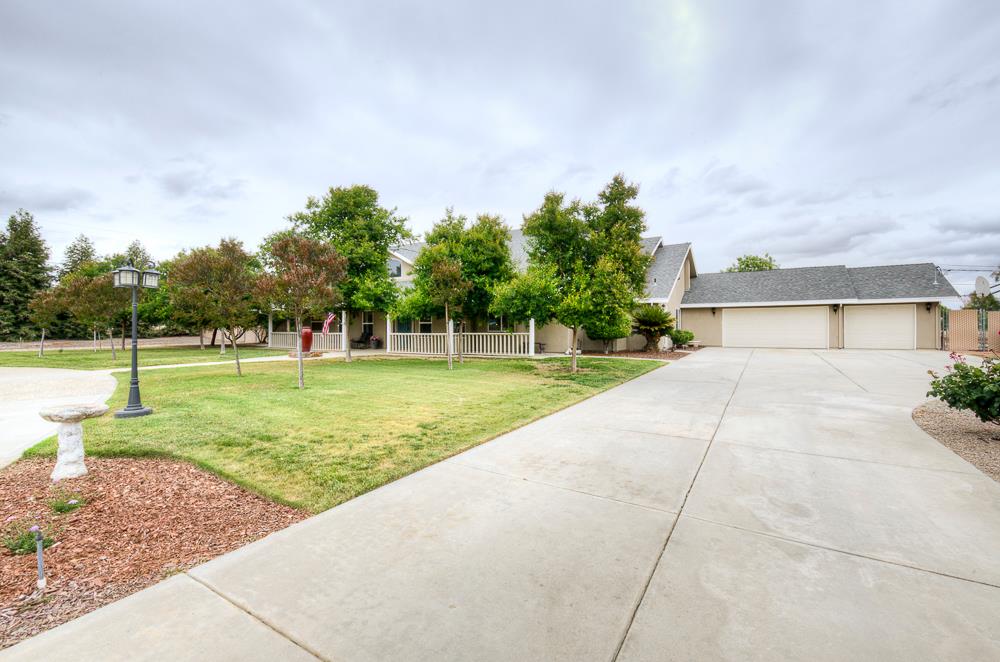 17465 Monreal Road Madera, CA 93636 - Photo 7 of 59 a view of a house with a big yard and a large trees