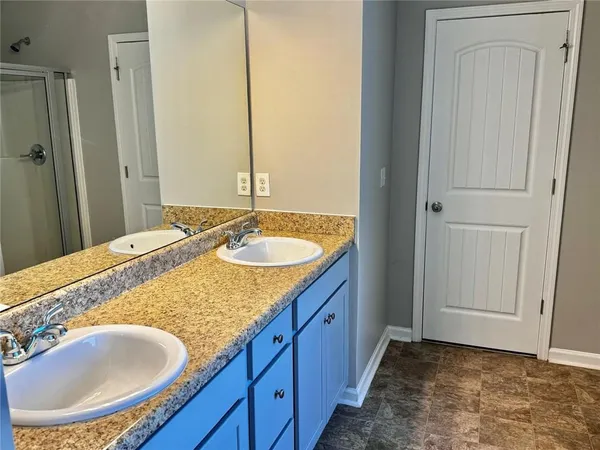 a en suite bathroom with a granite countertop sink and a mirror