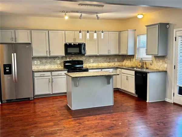 a kitchen with stainless steel appliances granite countertop a stove a sink and a refrigerator