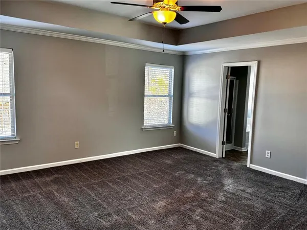 an empty room with window and chandelier fan