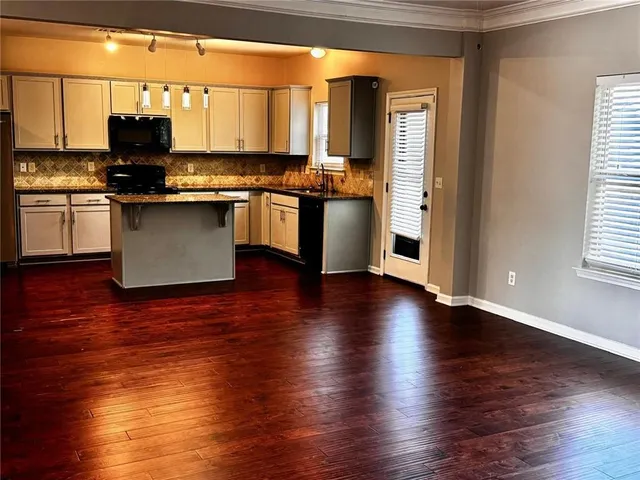 a kitchen with stainless steel appliances granite countertop a stove top oven a sink and a microwave