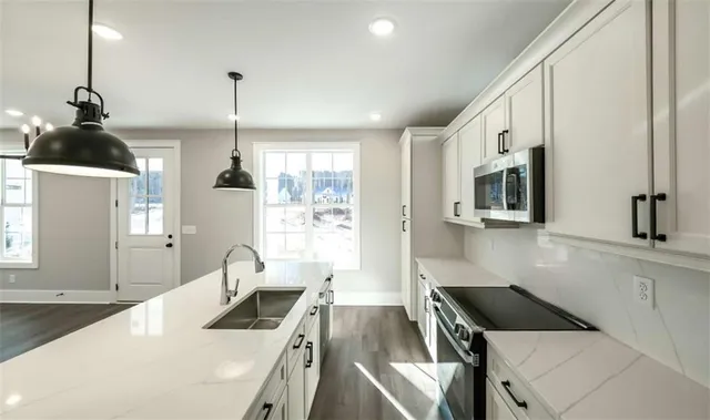 a kitchen that has a sink cabinets and a wooden floor