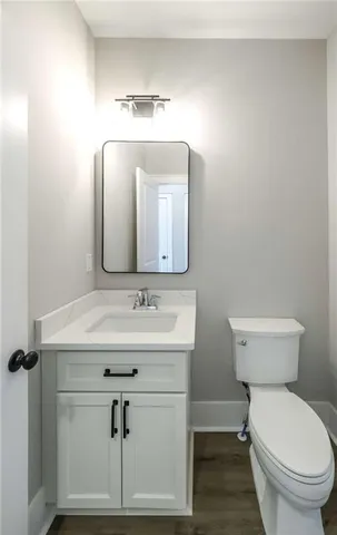 a bathroom with a toilet a sink and mirror