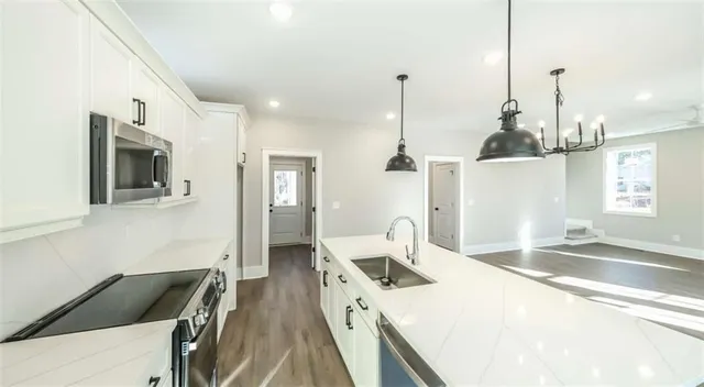 a kitchen with a sink a stove and microwave