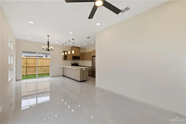 a large kitchen with a sink stainless steel appliances and cabinets