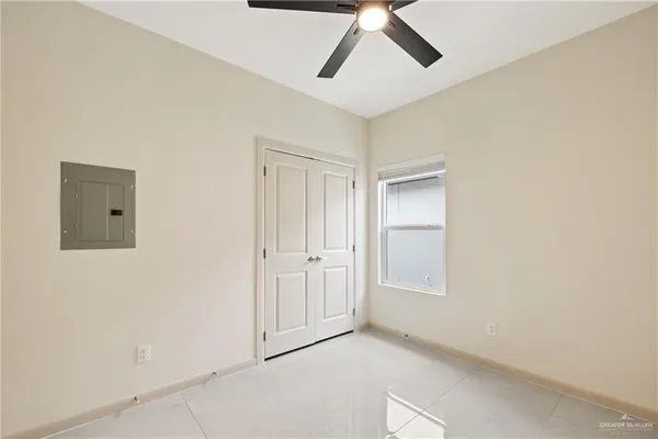an empty room with windows and fan