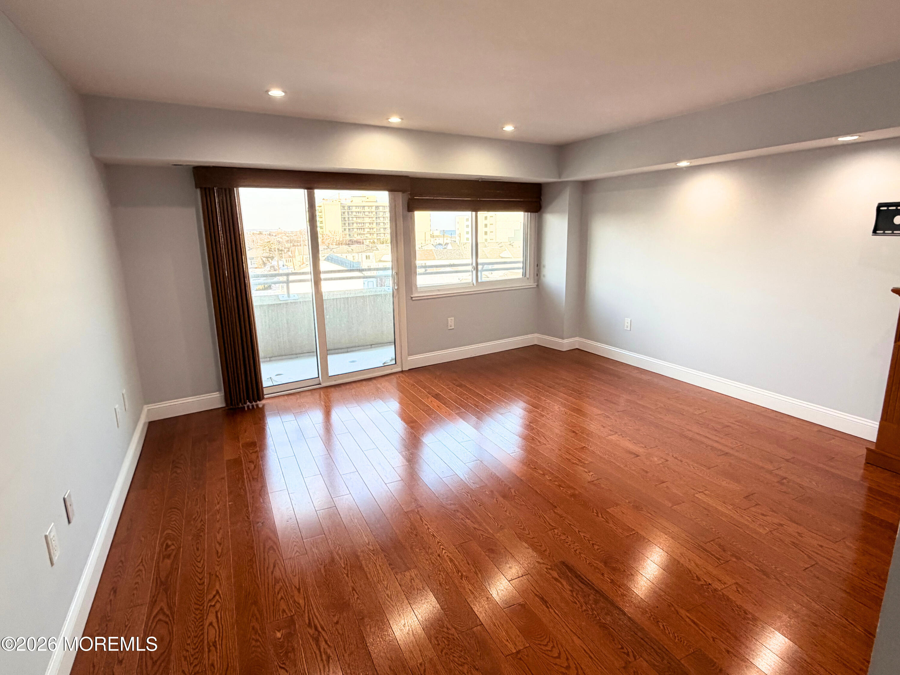 525 Ocean Boulevard, Unit 405 Long Branch, NJ 07740 - Photo 13 of 18 a view of an empty room with wooden floor and a window