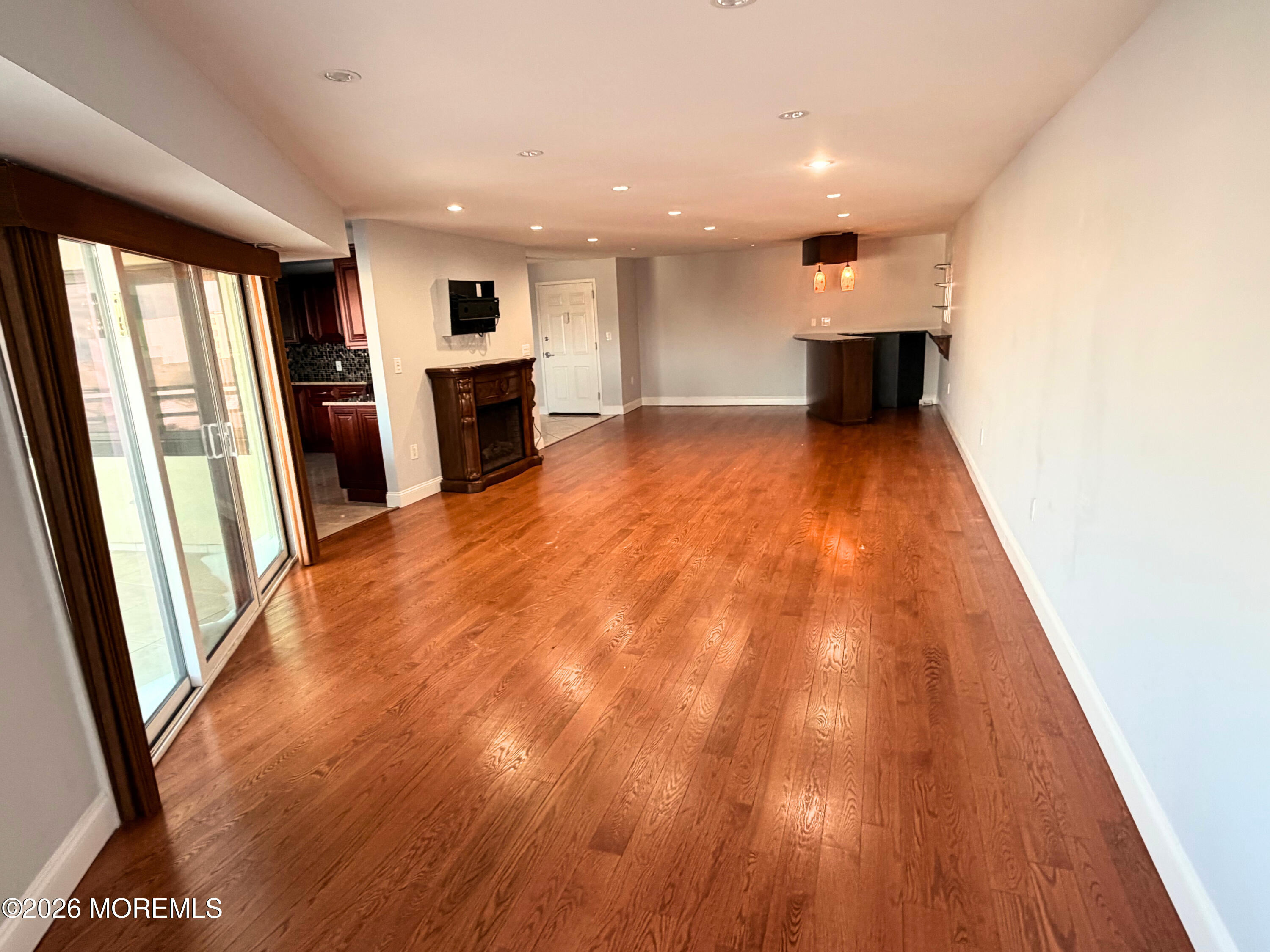 525 Ocean Boulevard, Unit 405 Long Branch, NJ 07740 - Photo 6 of 18 a view of empty room with wooden floor and fireplace