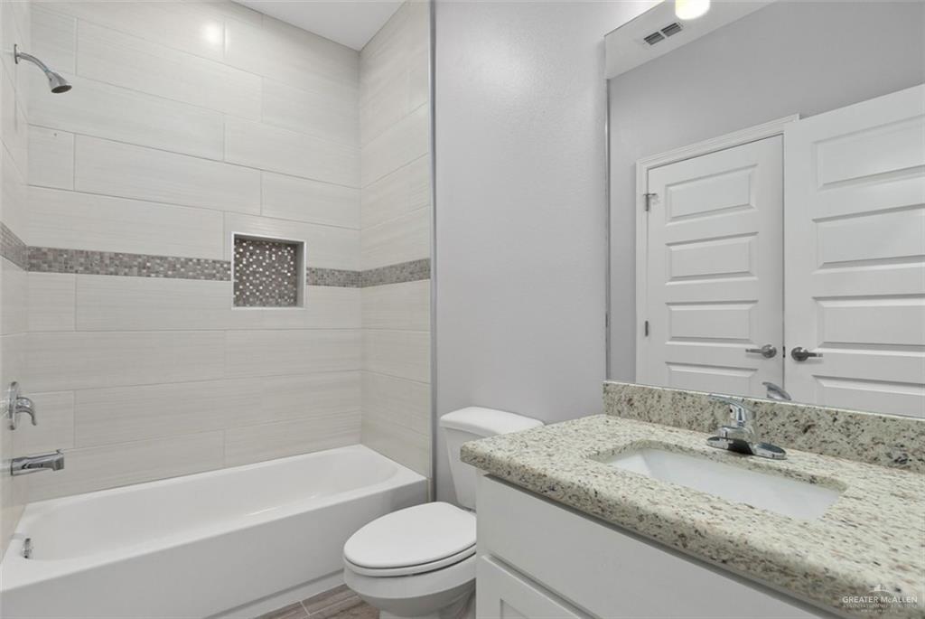 400 Retama Lane Weslaco, TX 78596 - Photo 8 of 10 a bathroom with a granite countertop bathtub toilet sink and mirror