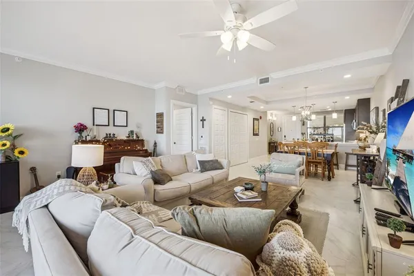 a living room with furniture kitchen view and a chandelier