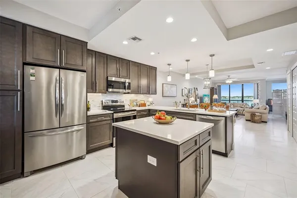 a kitchen with a refrigerator a stove top oven a sink and cabinets