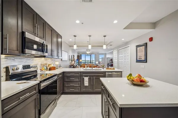 a kitchen with stainless steel appliances a sink a stove top oven a counter space and cabinets