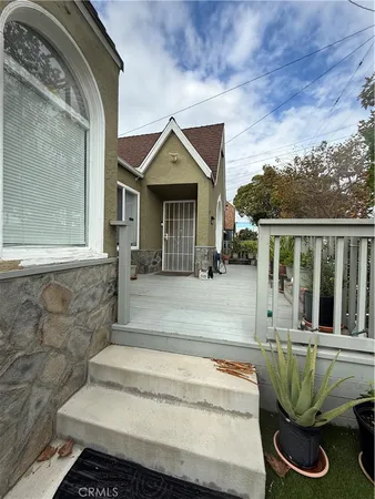 a front view of house along with deck and outdoor seating