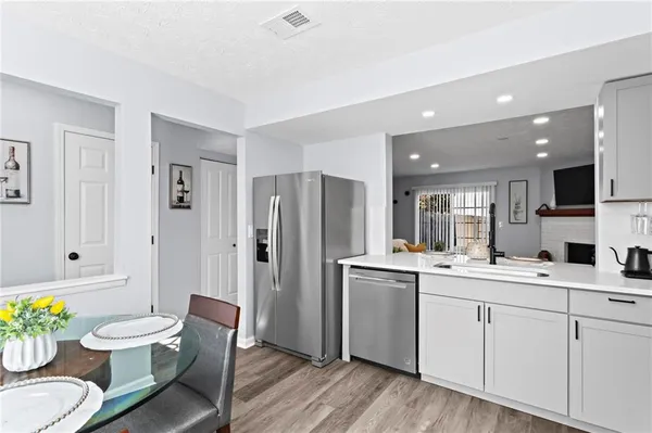 a kitchen with a sink stainless steel appliances and dining table