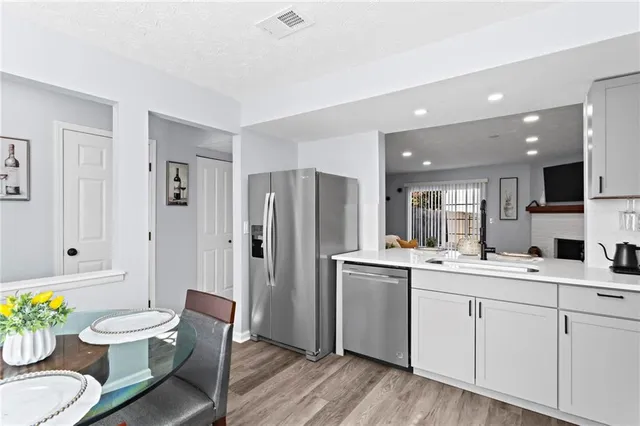 a kitchen with a sink stainless steel appliances and dining table